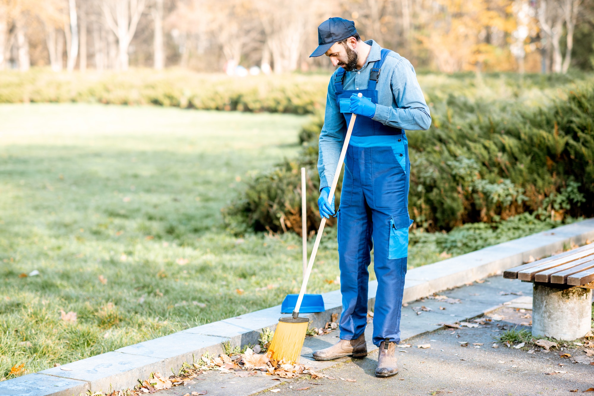 Cleaner sweeping leaves outdoors